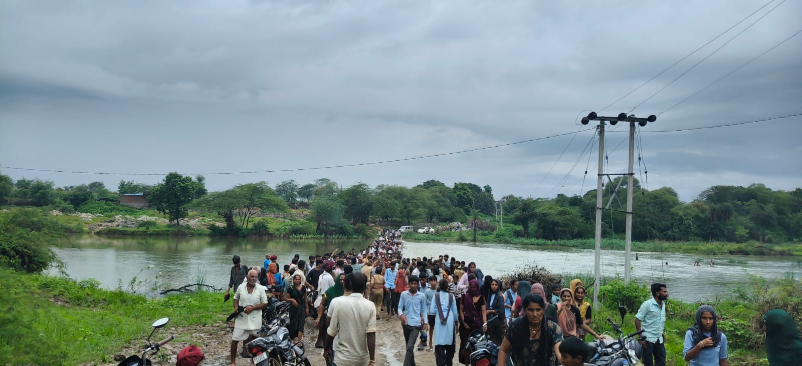 चित्तौड़गढ़ जिले के पारसोली थाना इलाके में रूपारेल नदी पर बाइक बहने के बाद मौके पर मौजूद ग्रामीण।