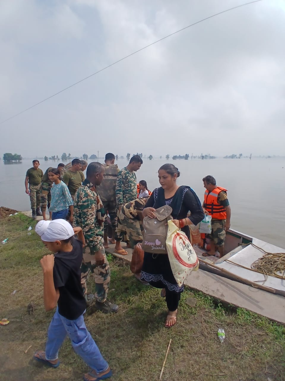 बाढ़ में फंसे लाेगाें काे निकालते बीएसएफ के जवान बाढ़ में फंसे लाेगाें काे निकालते बीएसएफ के जवान
