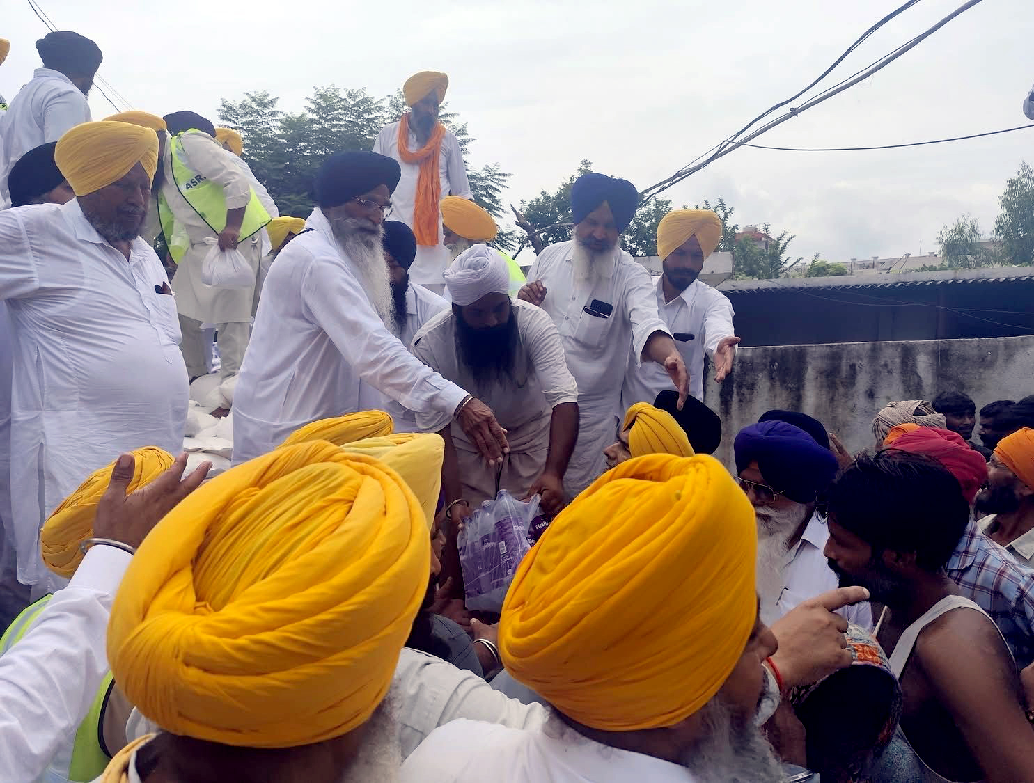 पंजाब में बाढ़ पीड़िताें की मदद करते स्वयं सेवक