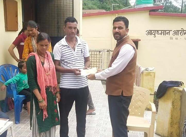 चैक वितरित करते अधिकारी। चैक वितरित करते अधिकारी।
