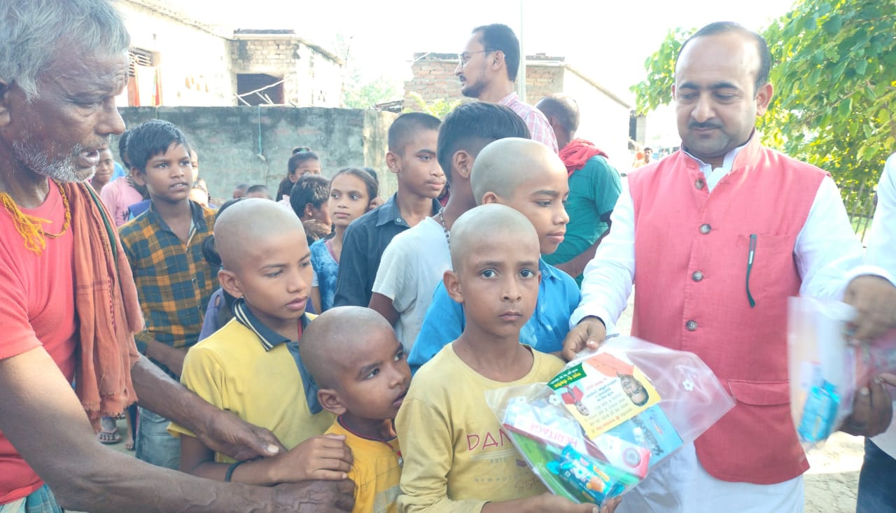 बच्चो के बीच पाठ्य सम्रागी वितरित करते यमुना सिकरिया