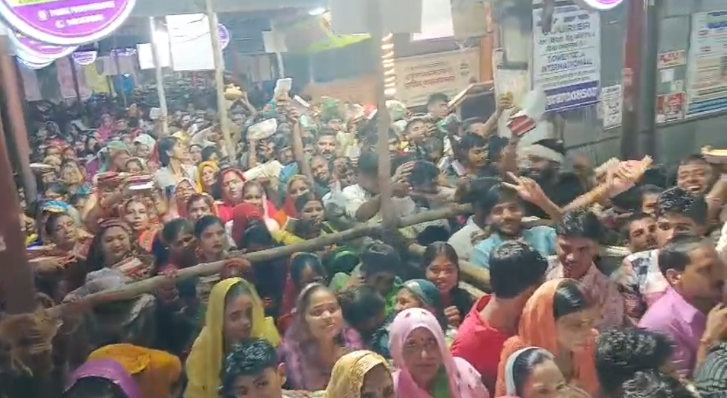 लाइनों में लगकर अपनी बारी का इंतजार करते श्रद्धालु