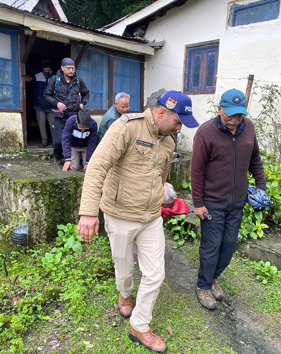 बीमार वृद्धा को स्ट्रेचर की मदद से सड़क तक पहुंचाने में जुटे पुलिस कर्मी।
