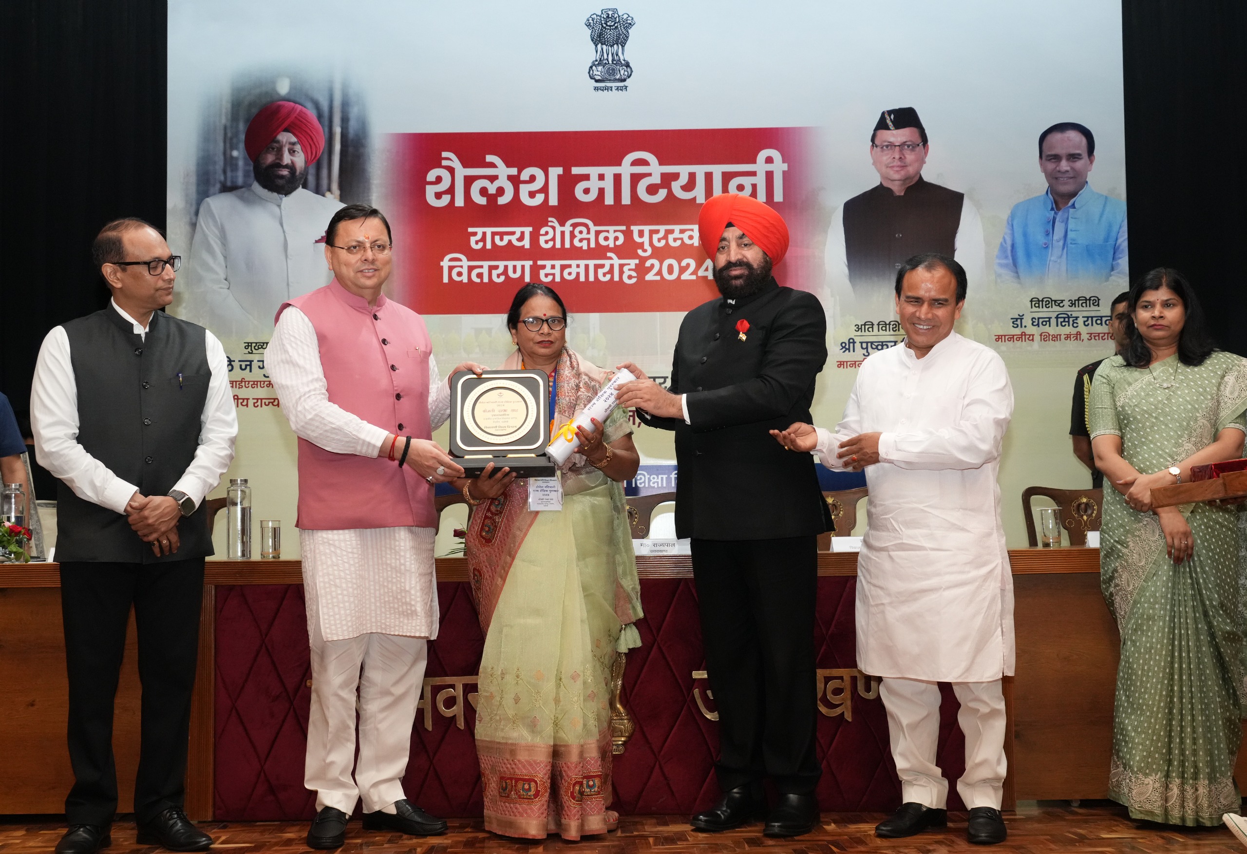 सम्मान समारोह में पुरस्कार लेती एक शिक्षिका।
