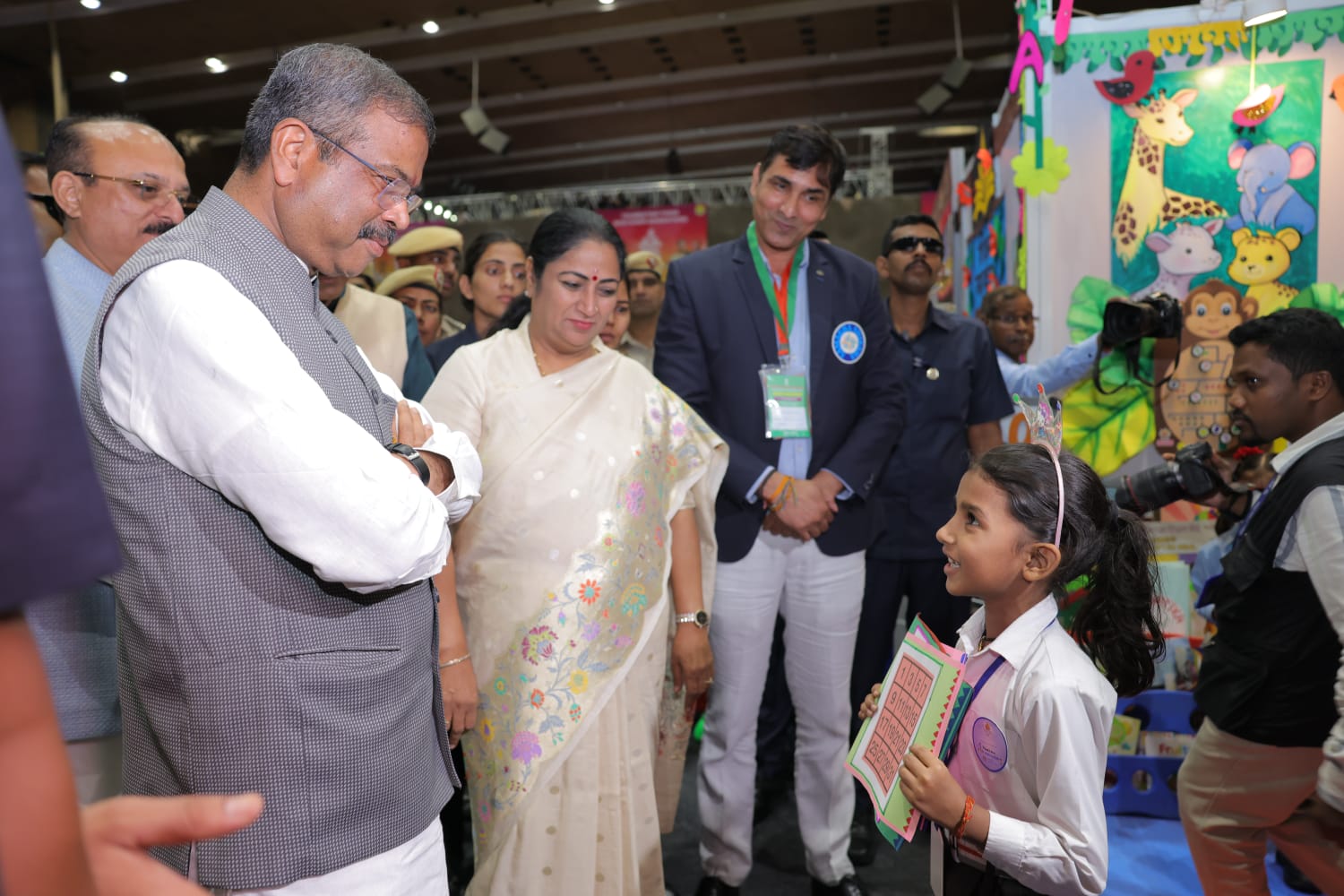 त्यागराज स्टेडियम में शिक्षक महाकुंभ के दौरान छात्र से संवाद करते केंद्रीय शिक्षा मंत्री धर्मेंद्र प्रधान,साथ में दिल्ली की मुख्यमंत्री रेखा गुप्ता