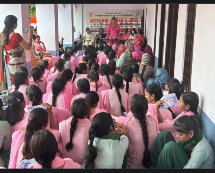 स्कूल में छात्राओं को जागरुक करते हुए आशा वर्कर