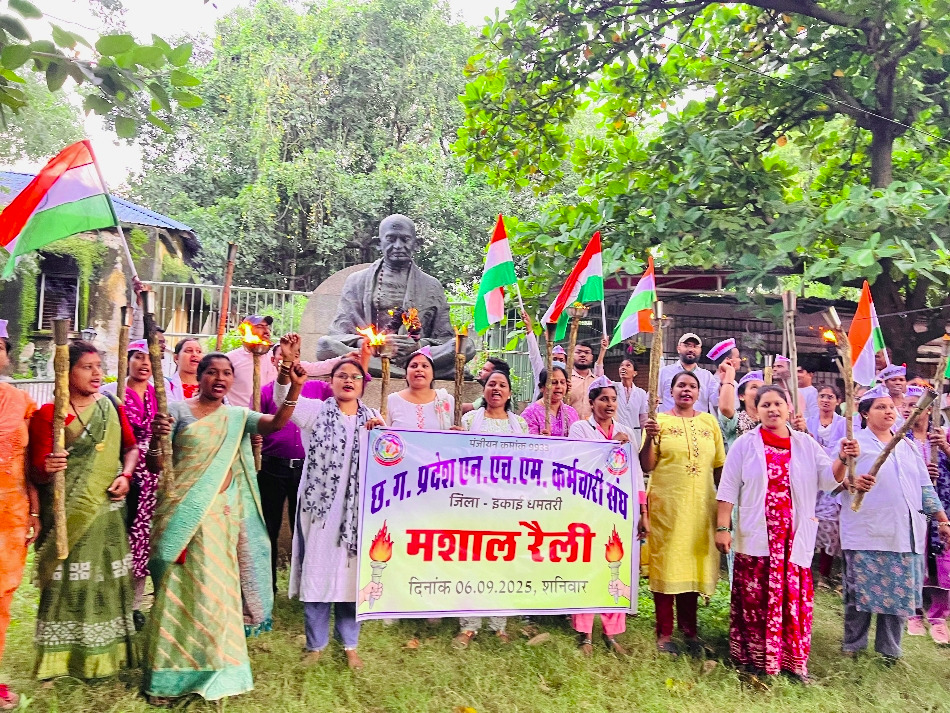 गांधी प्रतिमा के सामने मशाल लेकर खड़े हुए एनएचएम कर्मचारी।