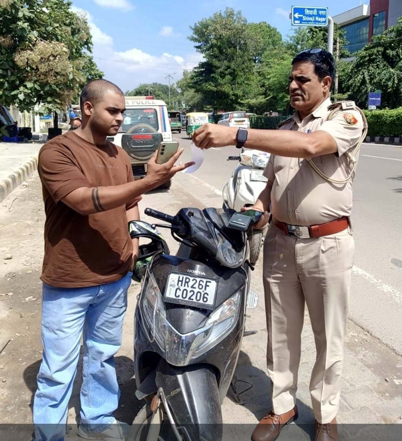 गुरुग्राम पुलिस आयुक्त कार्यालय के सामने उस स्कूटी को जब्त करते यातायात पुलिस अधिकारी, जिसके28 चालान की राशि दो लाख से अधिक बकाया है।