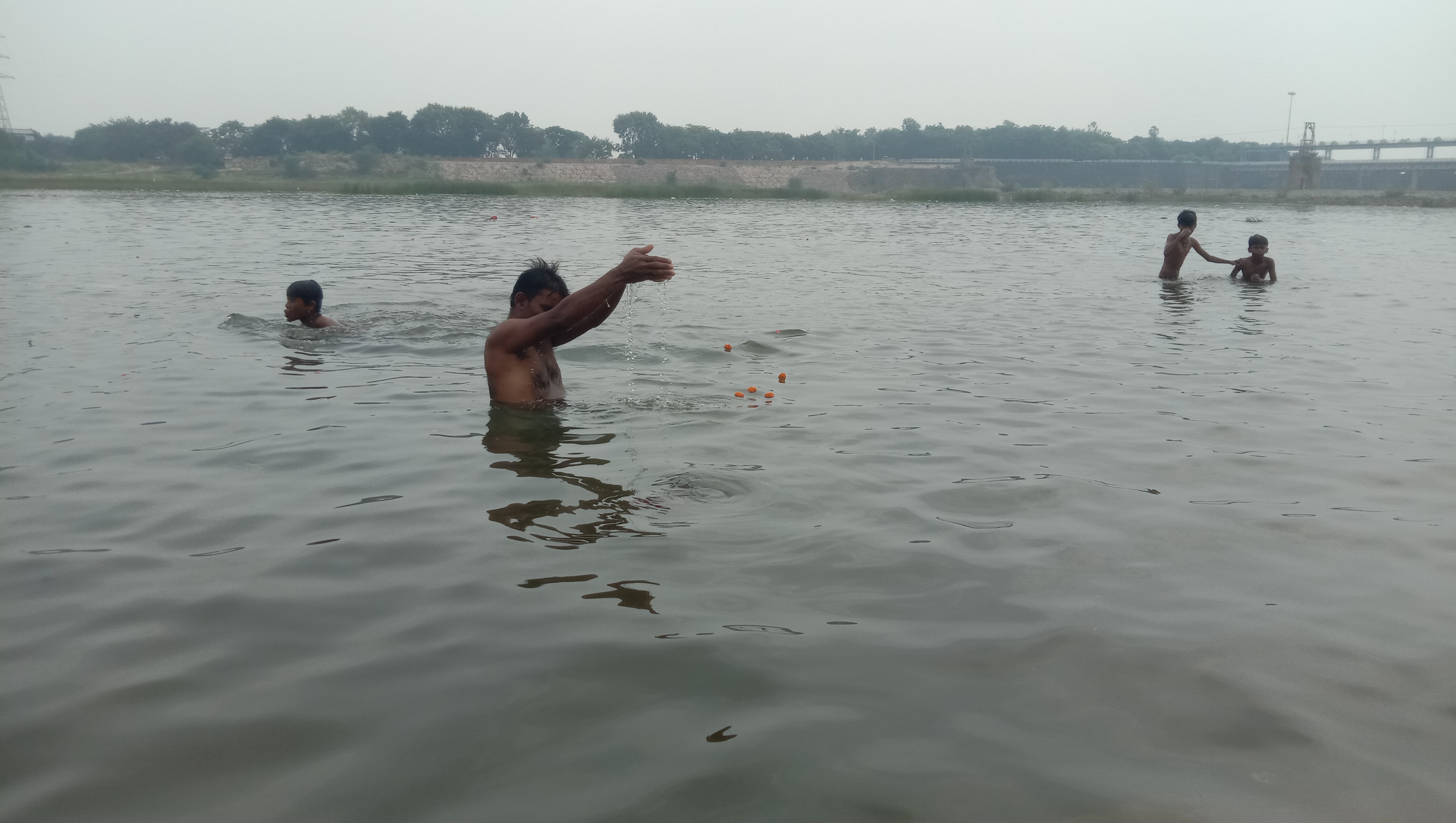 पितृपक्ष में जलाशय में पूर्वजों को अर्ध्य देता युवक।