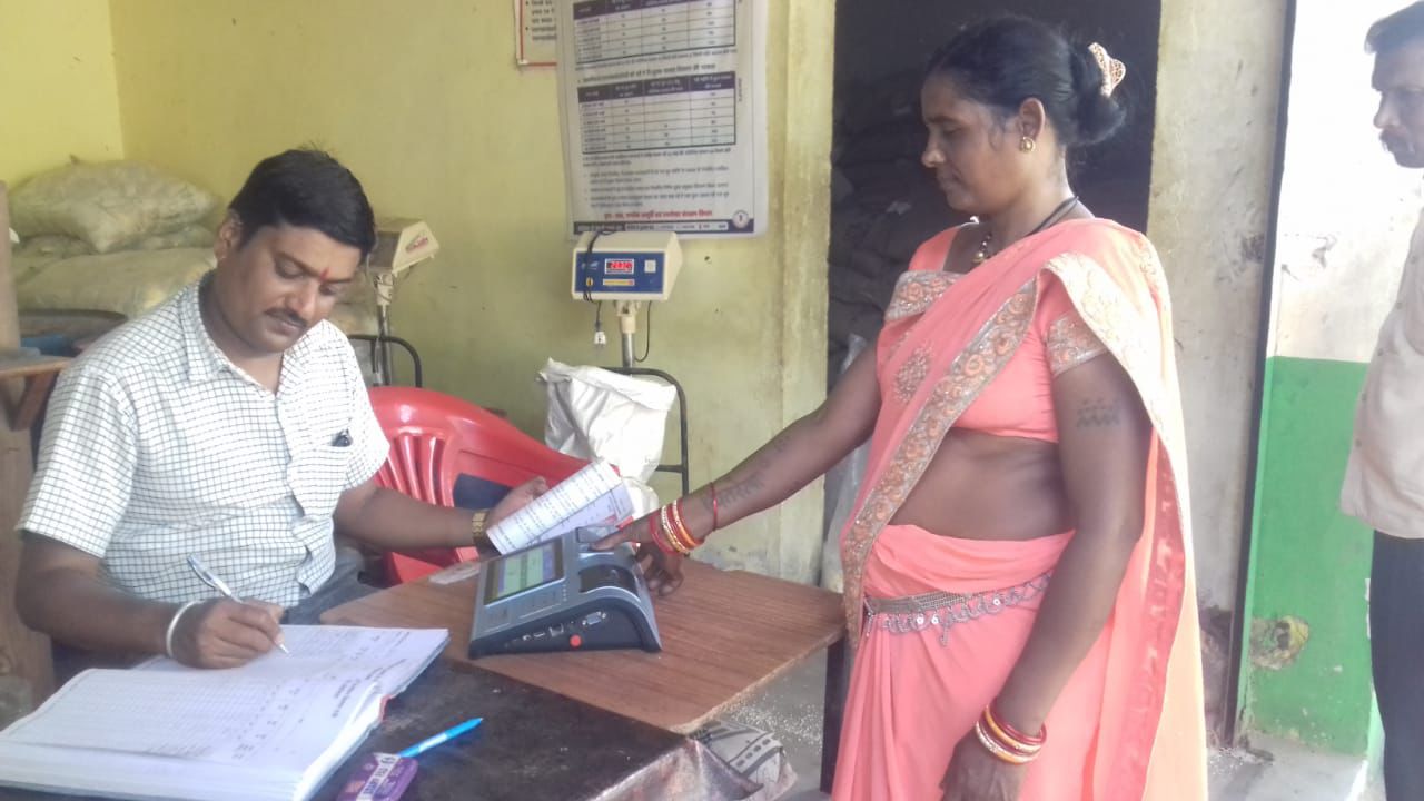 राशन दुकान में ग्राहक की एंट्री करता हुआ कर्मचारी।