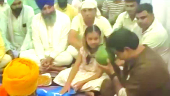 गुल्लक दान करती बच्ची