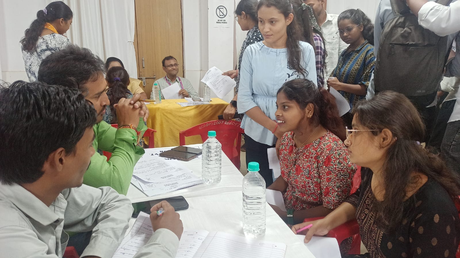 रोजगार मेला में लगे स्टाल में जानकारी लेते हुए युवा।