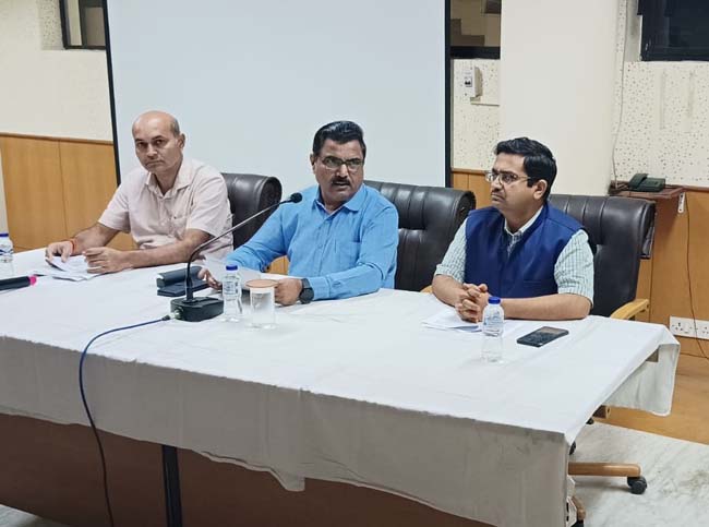 बीच में बैठे निदेशक वार्ता करते बीच में बैठे निदेशक वार्ता करते