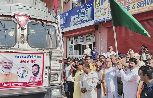 सोनीपत: मोहनलाल बडौली और विधायक पवन खरखौदा राहत सामग्री के ट्रक को रवाना करते हुए