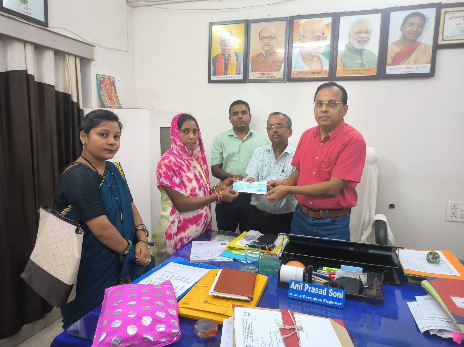 हितग्राही को अनुग्रह राशि भेंट करते हुए विभाग के अधिकारी।