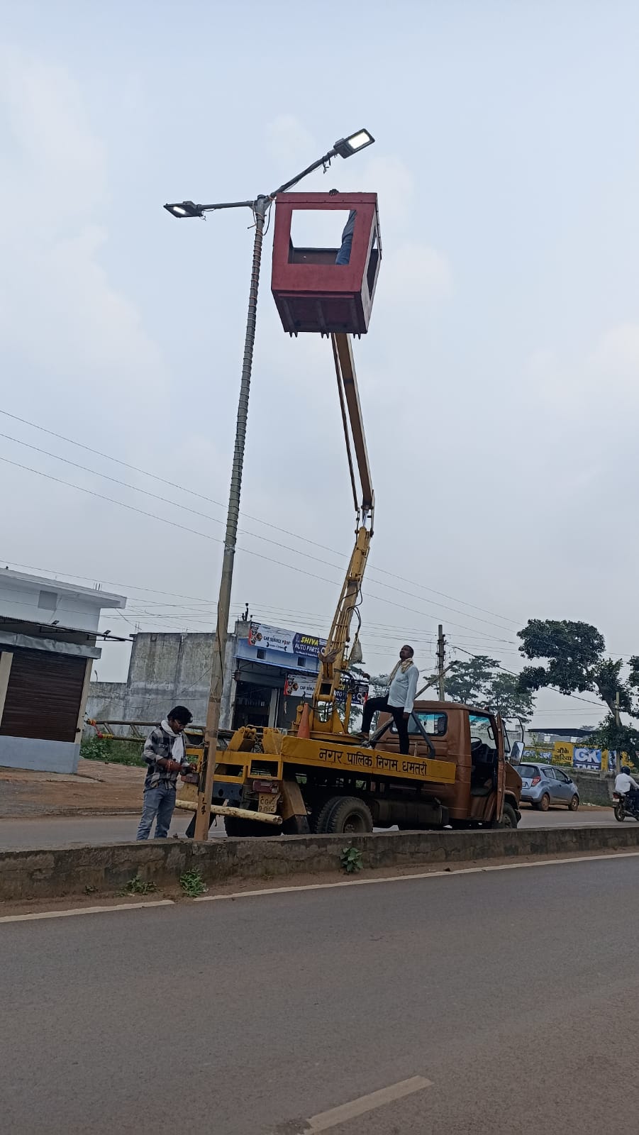 पोल की मरम्मत करते निगम कर्मचारी।