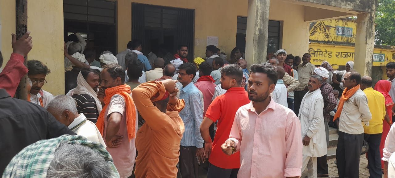 खाद लेने के लिए समिति पर जमा किसान।