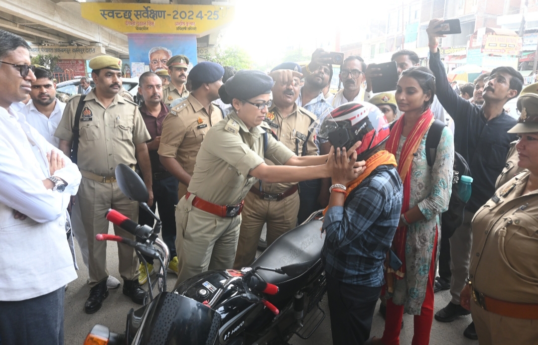 हेलमेट पहनाती पुलिस अधीक्षक