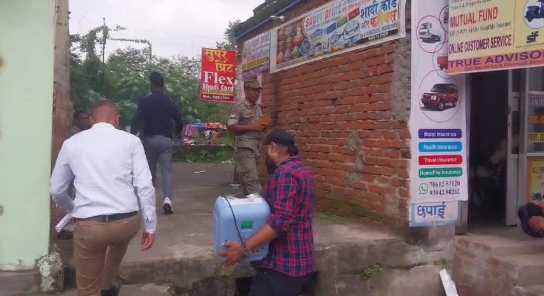 नोट गिनने की मशीन लेकर घर के अंदर जाती टीम