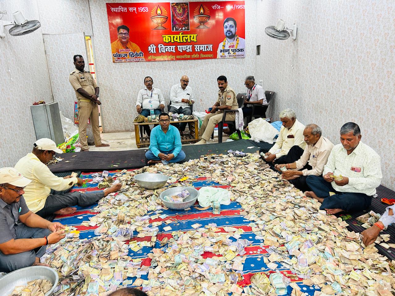 दान पेटिकाओं की गिनती करते राजस्व कर्मचारी।