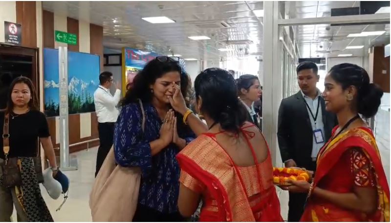 बागडोगरा हवाई अड्डे पर यात्रियों का माथे में तिलक लगाकर स्वागत करती महिला कर्मचारी