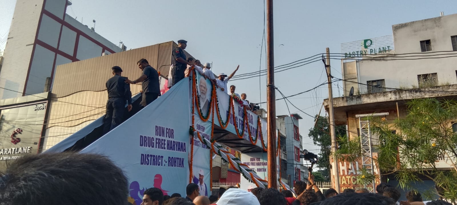 मैराथन दौड़ के दौरान फूलों की वर्षा करते मुख्यमंत्री नायब सैनी