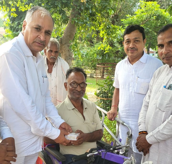 विधायक हरेंद्र राम रतन व वरिष्ठ भाजपा नेता जगमोहन गोयल फल वितरण करते हुए