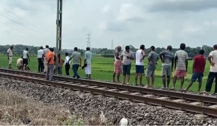 रेल लाइन के किनारे पड़े शव को देखते स्थानीय लोग