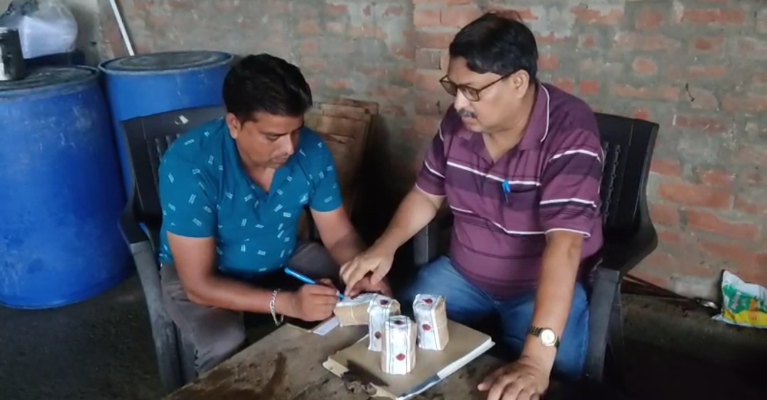 नमूने पर दुकानदार का हस्ताक्षर लेते हुए