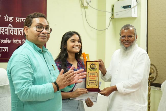 छात्रा को पुरस्कृत करते कुलसचिव