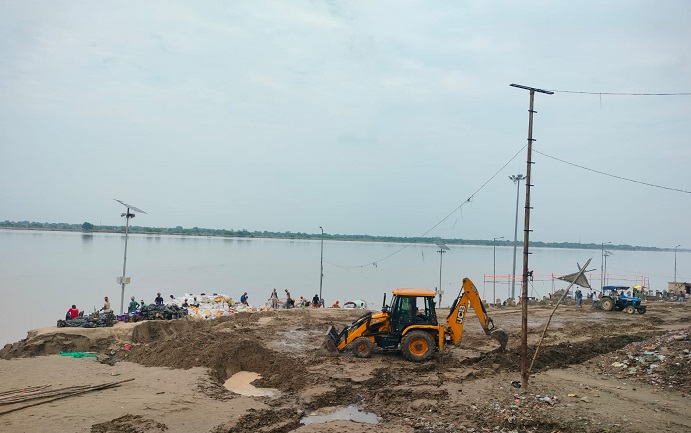 गंगा घाट की सफाई करते कर्मचारी।