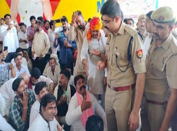 हंगामा करते लाेगाें काे समझाते पुलिस अधिकारी