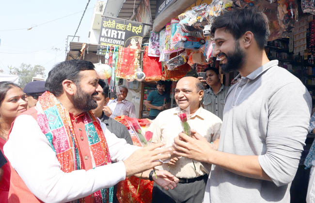 हरियाणा के मुख्यमंत्री जीएसटी उत्सव के दाैरान दुकानदाराें काे फूल भेंट करते हुए