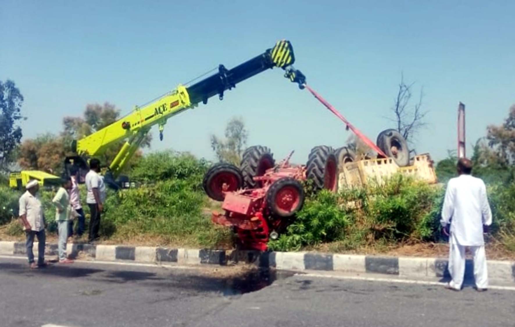 हादसे के बाद क्रेन की मदद से सड़क पर पलटी ट्रैक्टर ट्राली को हटवाते पुलिस कर्मी।