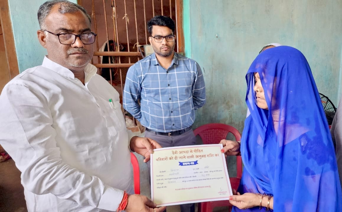 राज्य मंत्री गिरीश चंद्र यादव पीड़ित परिवार की चेक प्रदान करते हुए