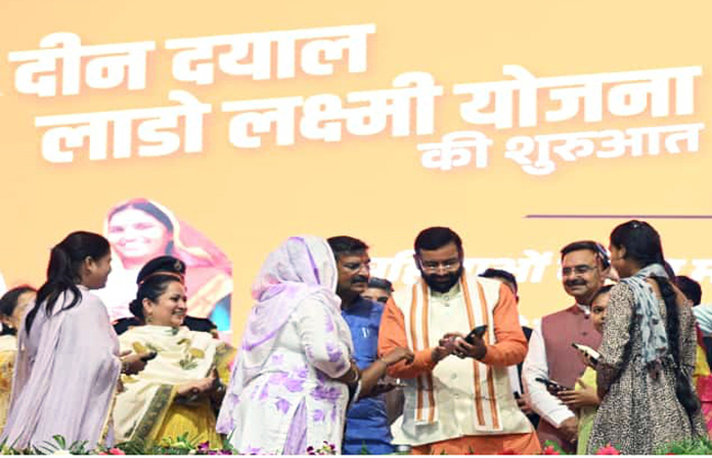 हरियाणा के मुख्यमंत्री लाडो लक्ष्मी योजना के लिए महिला का पंजीकरण करते हुए
