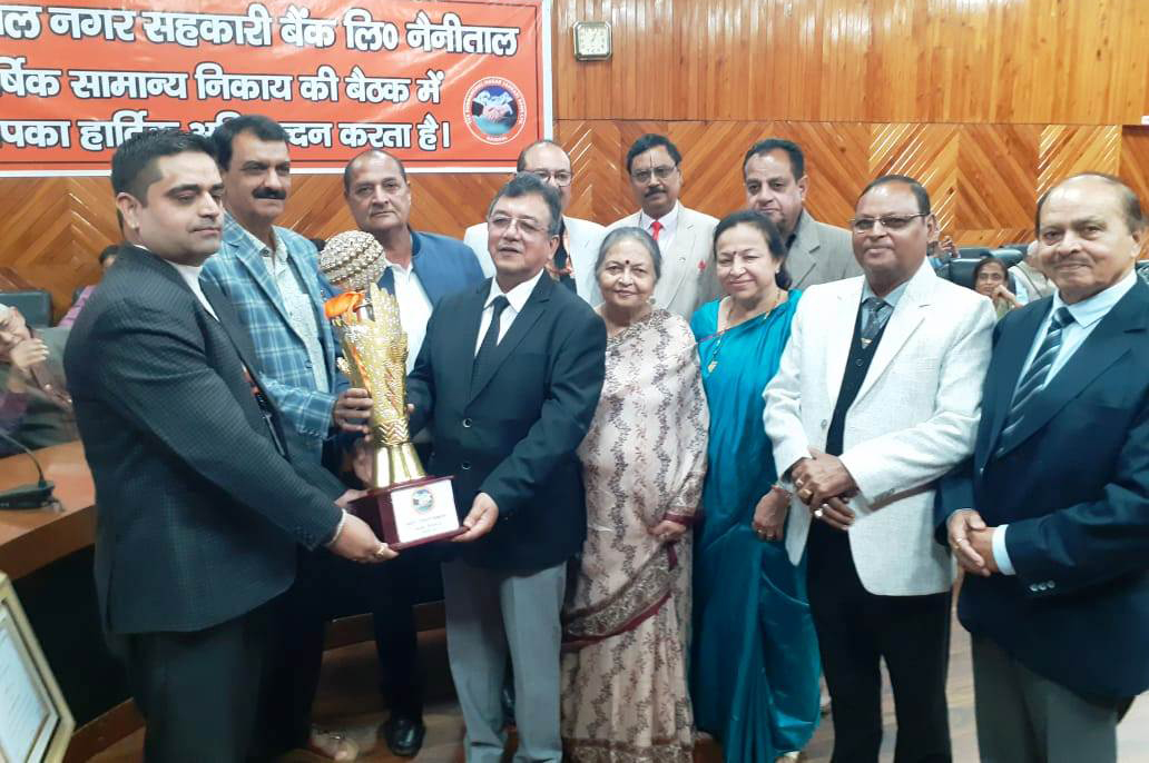 सर्वश्रेष्ठ शाखा को सम्मानित करते कूर्मांचल बैंक के अध्यक्ष विनय साह।