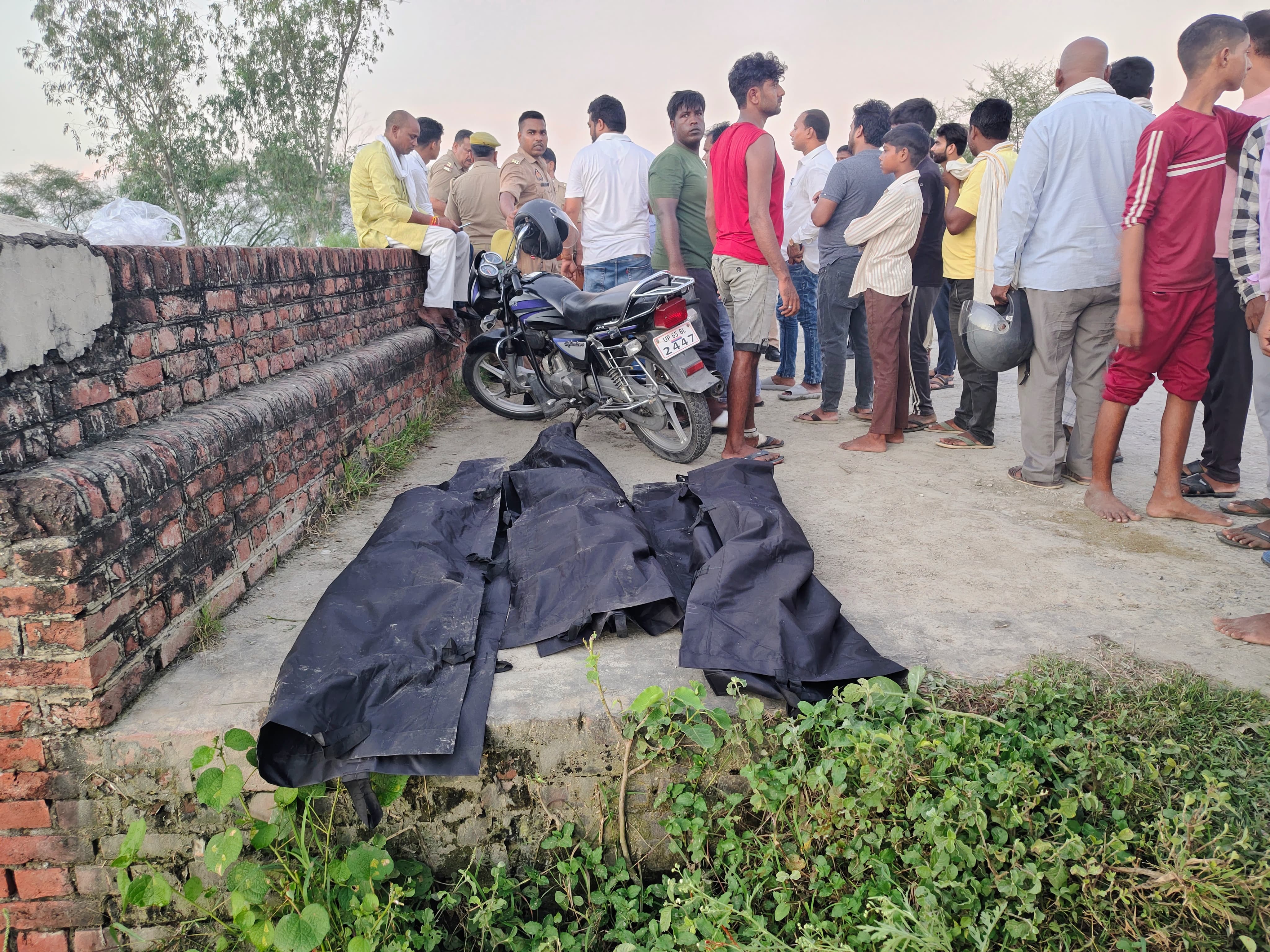 बच्चों के शव के पास खड़े ग्रामीण