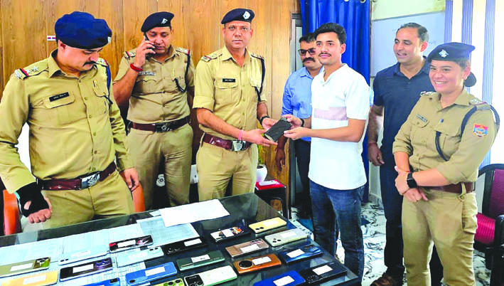 लोगों को मोबाइल लौटाते हुए