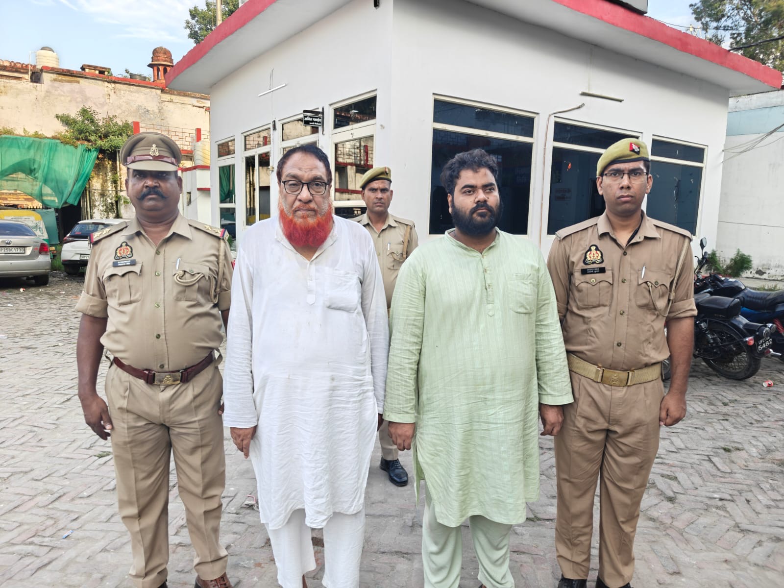 खलील तिराहे पर उपद्रव के मामले में गिरफ्तार किए गए डॉ. नफीस और उनके बेटे फरहान को मीडिया के सामने लाती पुलिस