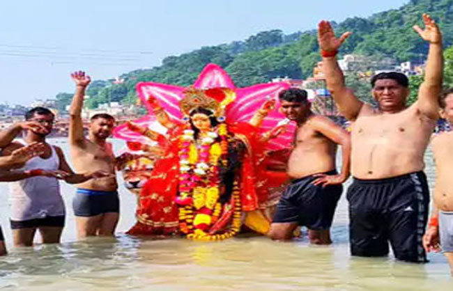 माता रानी की मूर्ति का विसर्जन करते हुए कार्यकर्ता।