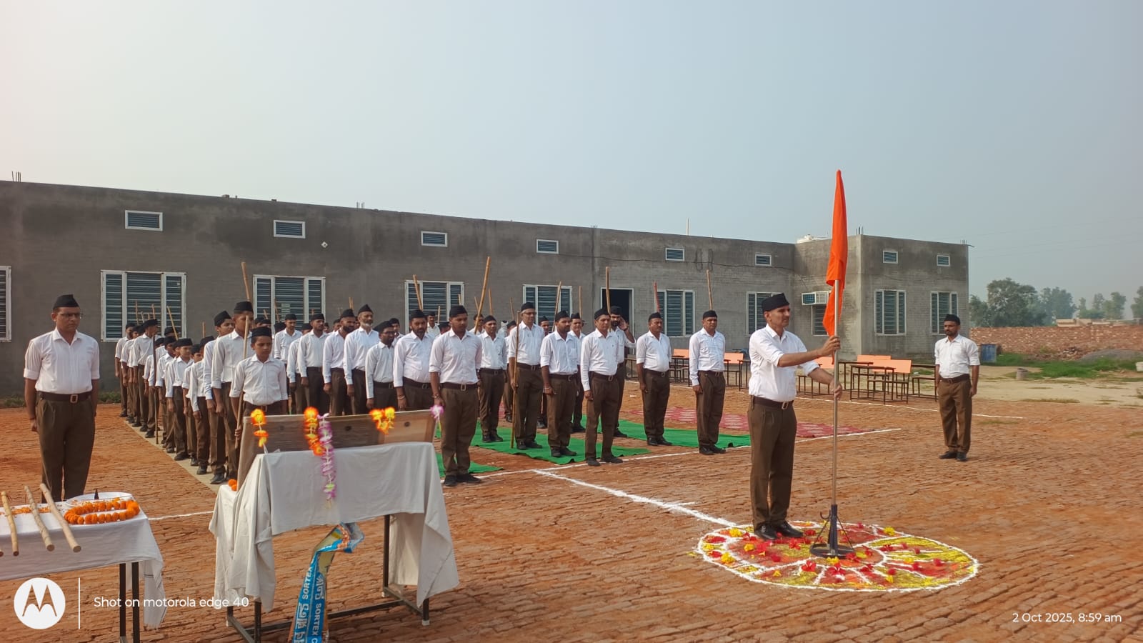 कार्यक्रम के दौरान भगवा ध्वज लगाते स्वयंसेवक।