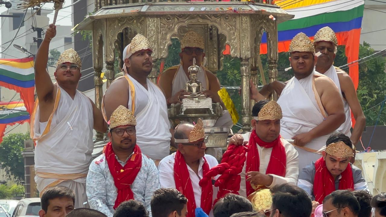 श्री पार्श्वनाथ दिगंबर जैन मंदिर के स्थापना दिवस पर धूमधाम से गाजे बाजे संग निकलती रथयात्रा में रथ पर सवार भगवान महावीर की प्रतिमा और जैन समाजके लोग। श्री पार्श्वनाथ दिगंबर जैन मंदिर के स्थापना दिवस पर धूमधाम से गाजे बाजे संग निकलती रथयात्रा में रथ पर सवार भगवान महावीर की प्रतिमा और जैन समाजके लोग।