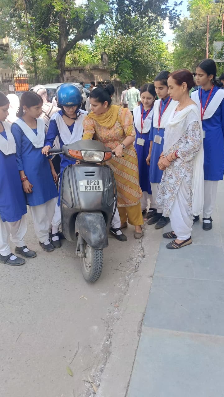 लड़कियों को ​स्कूटी सिखाती महिला
