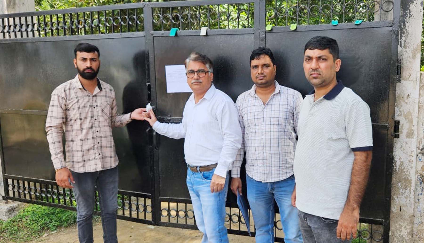 गुरुग्राम के कादीपुर में बकायेदार की प्रॉपर्टी सील करते नगर निगम के अधिकारी।