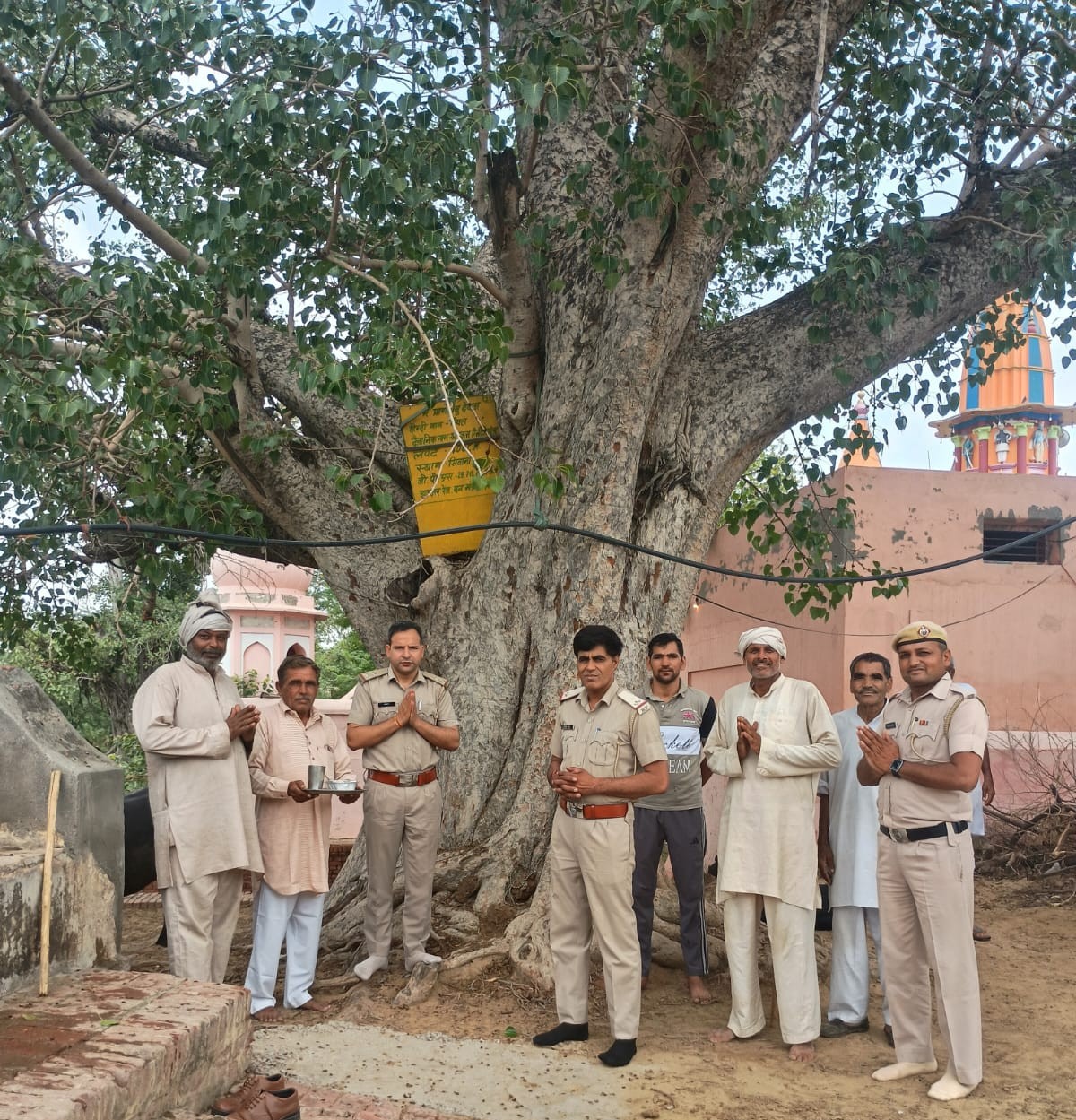 75 वर्ष पुराने पेड़ की छाया में ग्रामीणों के साथ वन विभाग के अधिकारी।