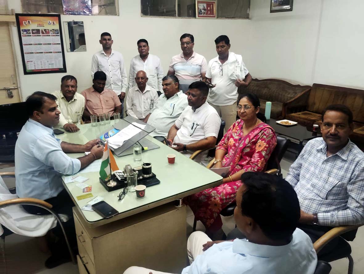 बैठक करते अधिकारी व गणमान्य व्यक्ति।