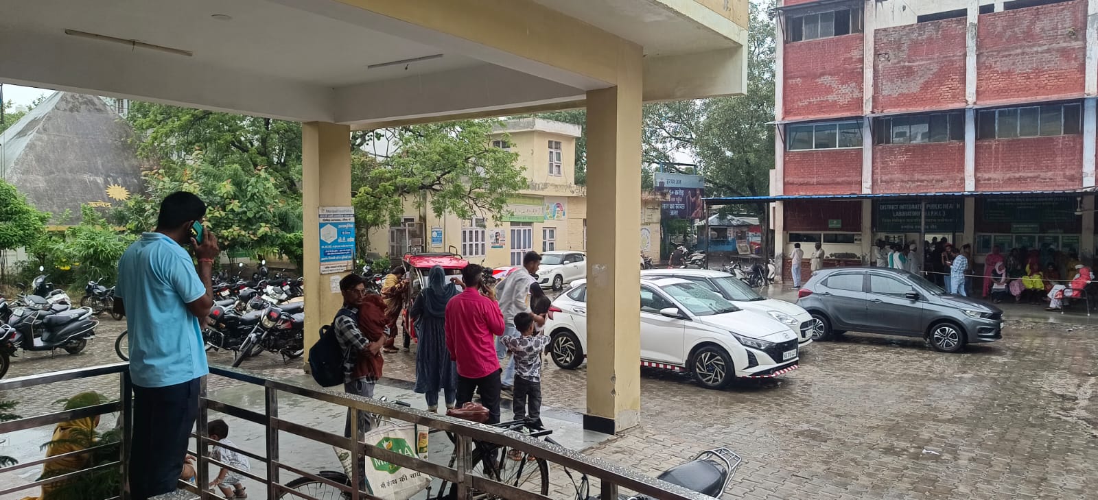 बारिश के बीच खड़े लोग।