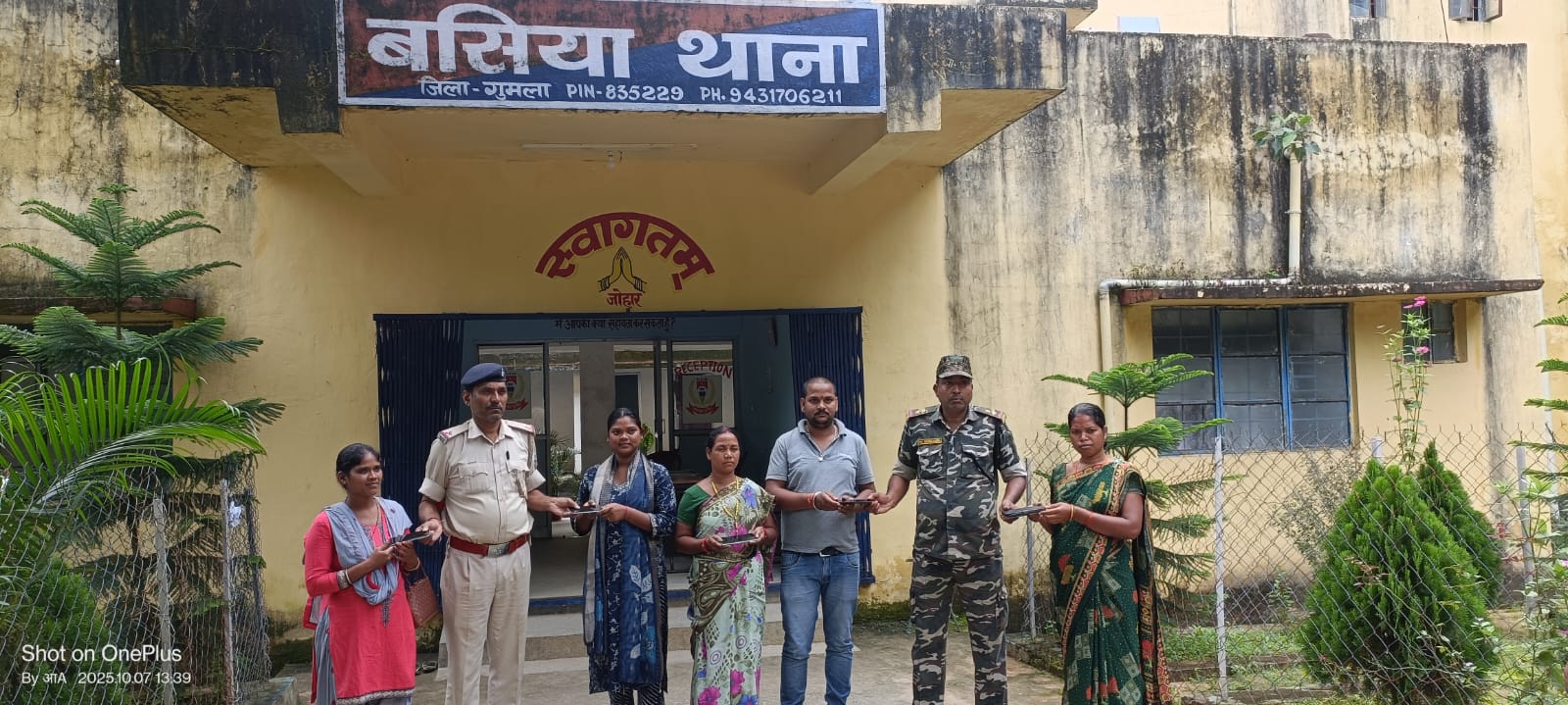 बसिया थाना में मोबाइल वापस करते पुलिस और उपभोक्ता