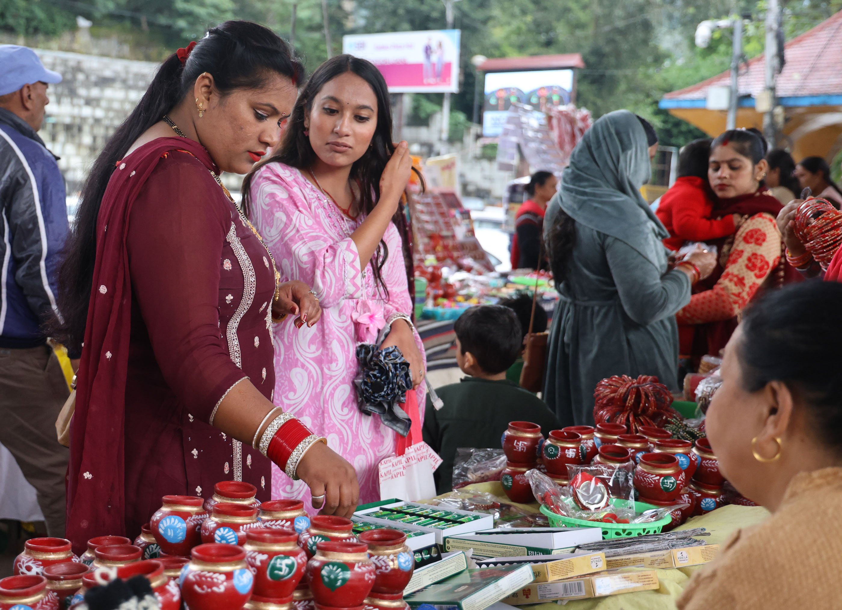बारिश के बीच मंडी में करवा चौथ की खरीदारी में व्यस्त महिलाएं।